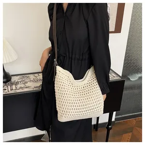 Détail du sac seau en maille ajourée tissé main avec bandoulière en cuir marron contrasté
