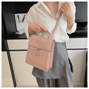 Detail view of pink tote bag featuring geometric embossed texture and metal zipper charms