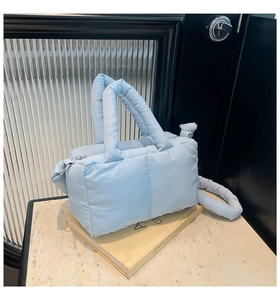 Détail du sac cabas en duvet matelassé bleu clair avec texture rembourrée et poignées