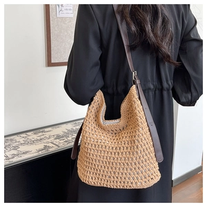 Détail du sac hobo en paille tressée avec bandoulière réglable en cuir marron foncé