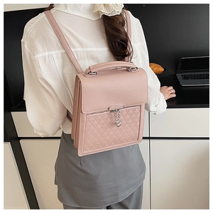 Close-up of pink quilted leather backpack with silver chain detail on model