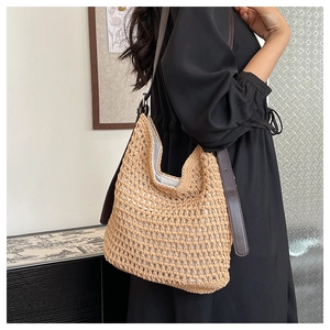 Détail du sac hobo tissé main beige avec bandoulière en cuir marron et boucles argentées