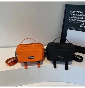 Detail view of small nylon crossbody bags in bright orange and black colors