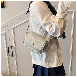 Detail of light gray lychee pattern leather crossbody bag with silver metal hooks