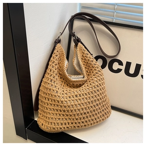 Détail du sac hobo en paille tressée à la main avec bandoulière en cuir marron réglable