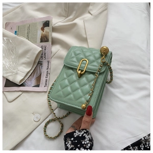Detail of light green quilted mobile bag with gold chain and sphere ornament