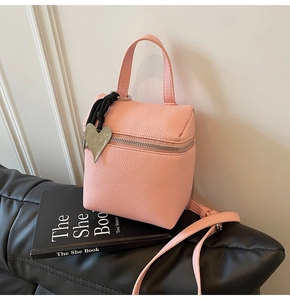 Dettaglio della mini borsa quadrata rosa con trama litchi e ciondolo a cuore argento
