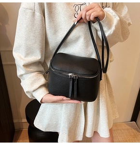 Detailansicht aus schwarzem Litschileder mit Doppelreißverschluss an der Mini-Tasche