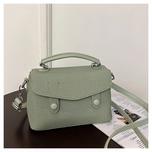 Detail of sage green structured handbag with twill fabric texture and silver hardware