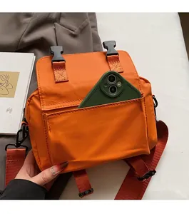 Macro view of bright orange messenger bag with front pocket for smartphone storage