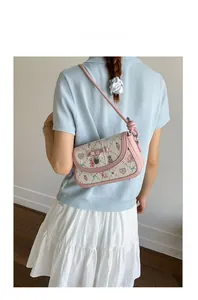 Detailed back view of model wearing cream woven crossbody bag with pink bow and floral print