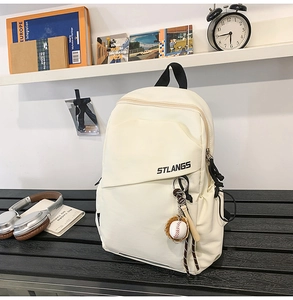 Dettaglio borsa a tracolla in tela crema con stampa STLANGS e portachiavi da baseball