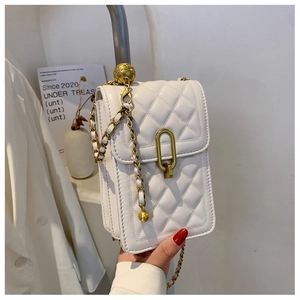 Macro detail of white quilted crossbody bag with gold adjustable ball chain strap