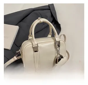 Detail of off-white box bag with silver metal chain, heart pendant and detachable strap
