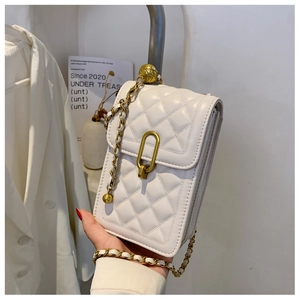 Detailed macro view of quilted cream leather cross-body bag with gold hardware ring