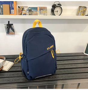 Dettaglio dello zaino sportivo blu navy con cerniere gialle su una panchina di legno