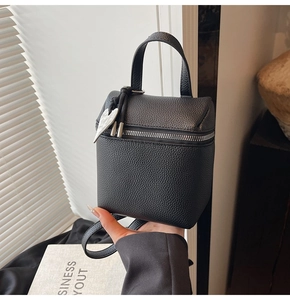 Dettaglio mini borsa in pelle martellata nera con ciondolo a cuore argento e tracolla