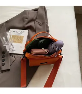 Interior view of large capacity orange crossbody bag showing umbrella and phone storage