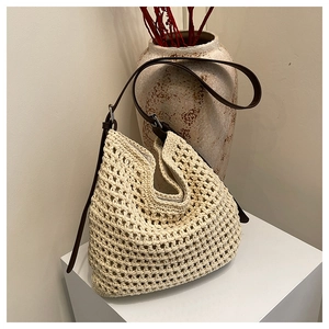 Détail d'un sac cabas tissé avec texture crochet crème et lanières en cuir marron foncé