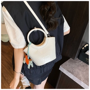 White croc-effect bucket bag with round handle and horse charm shown on model