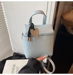 Dettaglio pelle martellata celeste su mini borsa a cubo con ciondolo a cuore argento