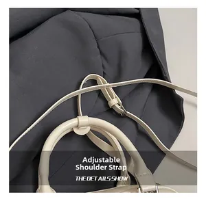 Detailed macro view of beige handbag showing adjustable shoulder strap and silver buckle
