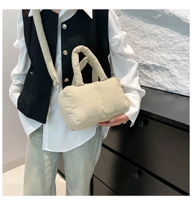 Sac fourre-tout matelassé beige avec bandoulière réglable porté par un mannequin