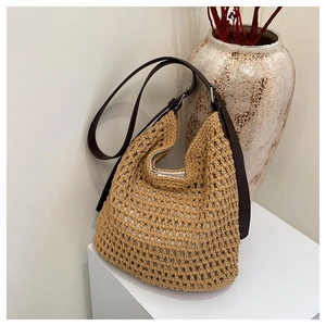 Détail du sac hobo en paille tissée main avec bandoulière en cuir réglable en décor minimaliste