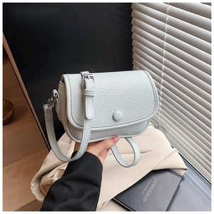 Detail showing mint green lychee pattern leather handbag with silver round buckle strap
