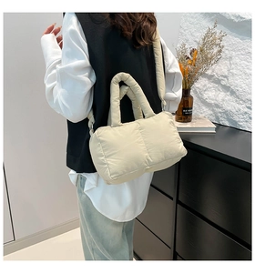 Gros plan du sac fourre-tout matelassé beige montrant la texture douce et la bandoulière