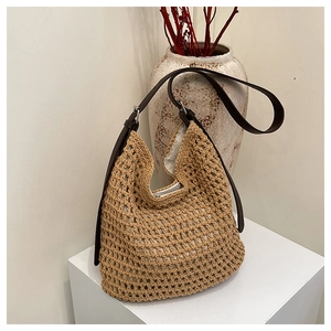 Détail d'un sac à bandoulière en paille tressée avec texture maille et bandoulière en cuir