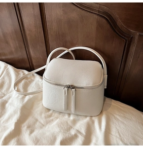 Detailansicht einer weißen Mini-Box-Tasche aus Leder mit silbernen Beschlägen