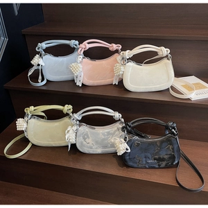 Selection of half-moon shoulder bags with knotted handles and pearl charms in various colors