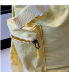 Detail shot of smooth zipper with nylon pull cord on light yellow canvas backpack