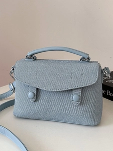 Chic light blue twill crossbody bag with top handle and decorative double buckles