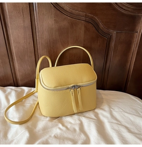 Detailansicht der gelben Handtasche aus Leder mit Doppelelement und Reißverschluss