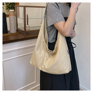 Close-up of minimalist cream canvas tote bag showing textured fabric and brand label