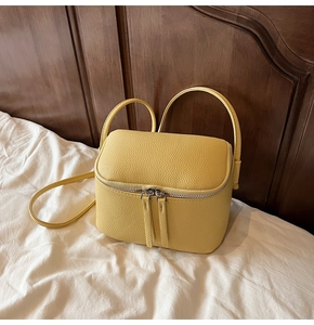 Detailansicht der gelben Mini-Tasche aus Leder mit Litschi-Maserung und Doppel-Reißverschluss