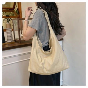 Spacious canvas tote bag in beige shown in a cozy cafe setting for casual commuting