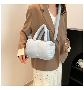 Détail d'un sac cabas matelassé bleu clair avec texture nuage douce et large bandoulière
