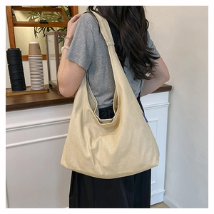 Detail of beige canvas tote bag with minimalist blue tag shown in lifestyle setting