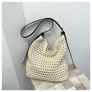 Détail du sac à bandoulière en crochet à larges mailles et bandoulière en cuir brun