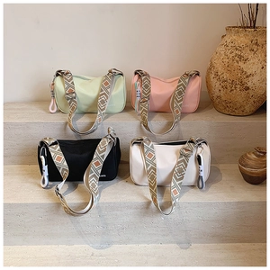 Détail de quatre sacs polochons en nylon avec bandoulières à motifs sur marches