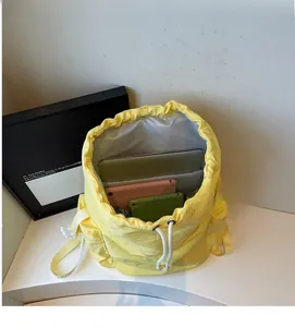Macro view showing spacious interior of yellow drawstring backpack with laptops