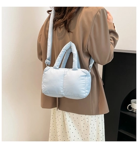 Vue arrière d'un sac à bandoulière matelassé bleu clair avec une large sangle confortable