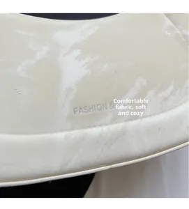 Detail of soft white marble texture synthetic leather with silver logo embossing