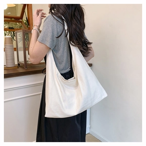 Minimalist white canvas tote bag shown in use at a cafe for a casual commute look