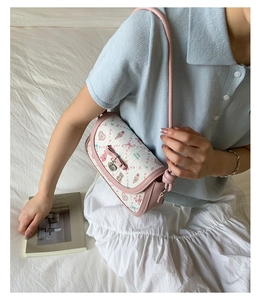 Detail of pink bow and heart pendant on ballet style crossbody bag with bear prints