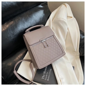 Detailed view of taupe crossbody bag with geometric quilting and metallic sphere zipper