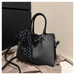 Détail du sac à main gris foncé texturé avec foulard à pois et boucles argentées